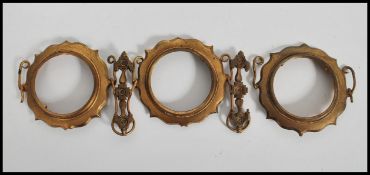 A group of three 19th century gilt ormolu circular tondo picture frames, linked with gilt chains.
