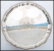 A Silver hallmarked Salver, with bead border raised on four ball and claw pad  feet, possibly with