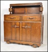 A 1930's Art Deco oak buffet / sideboard. Raised on shaped feet with cupboard above having stage
