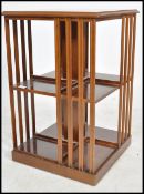 An Edwardian mahogany revolving inlaid style bookcase having sectional body with slatted sides and