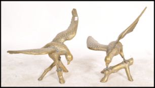 A large pair of 20th century brass models of eagles on perched with out stretched wings.