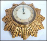 A vintage mid 20th century retro Smiths sunburst wall clock. The two tone dial having arabic