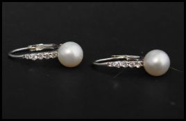 Two pairs of 925 silver and pearl earrings . Marked 925. (one back missing)