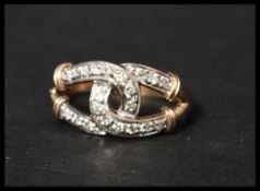 A hallmarked 9ct gold and diamond ring featuring linked lucky horseshoes set with diamonds. Size