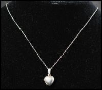 A 925 silver locket pendant necklace strung with a locket in the form of a heart. Chain measures