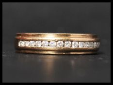 A hallmarked 9ct gold and diamond band ring set with 15 round cut diamonds totalling approximately