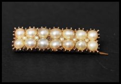 A 9ct gold Victorian bar brooch set with seed and blister pearls having a C clasp. Measures 3cms.