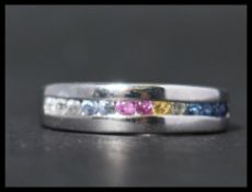 A hallmarked 9ct white gold and sapphire half eternity ring having channel set round cut multicolour