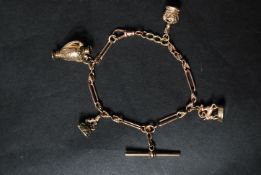 A hallmarked 9ct gold Albert style chain charm bracelet strung with three 9ct gold charms and one