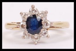 An 18ct gold diamond and sapphire ladies ring having a halo of diamonds around the oval sapphire.