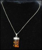 A 925 silver pendant necklace strung with an amber set  block pendant. Marked 925 to pendant and