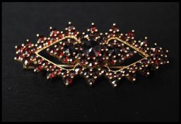 A 925 silver vermeil bohemian garnet brooch having a trombone clasp. Marked HG 925.