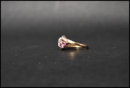 A hallmarked 9ct gold sapphire and diamond ring set with pink oval cut sapphires and round cut
