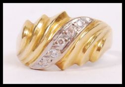 An 18ct gold and diamond ladies ring having a wave setting with central channel set 5 stones.