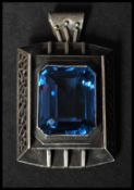 A Liberty style white metal brooch pendant having set with a large blue stone having a stylised