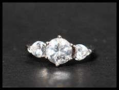 A hallmarked 9ct white gold ring set with a central round cut CZ and accent heart shaped CZ to