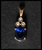 A hallmarked 9ct gold blue sapphire and diamond drop pendant. Set with an oval cut blue sapphire