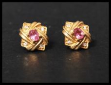 A pair of 18ct gold and diamond earrings set with four round cut diamonds in each with central