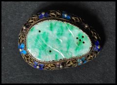 A 1920's Chinese export silver, enamel and carved jade brooch pin having a central carved jade