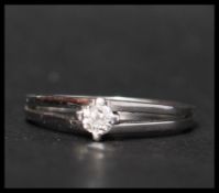 A 14ct white gold and diamond solitaire ring. The diamond being prong set in a raised mount having