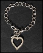 A 925 silver and CZ bracelet strung with a heart pendant set with CZ having a toggle clasp. Marked