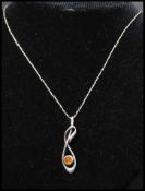 A 925 silver pendant necklace strung with an amber set pendant. Marked 925 to pendant and chain.