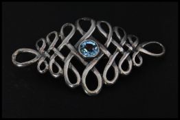 A vintage 925 silver brooch pin set with a blue stone, possibly topaz, having a roller clip clasp.