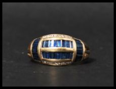 A 14ct gold blue sapphire and diamond ring having baguette cut blue sapphires and round cut diamonds