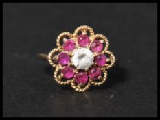 A hallmarked 9ct gold ruby and white stone cluster ring. Hallmarked London. Size S. Weight 3.4g.