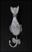 A 925 silver pendant brooch pin in the form of a cat being set with white stones and mother of pearl