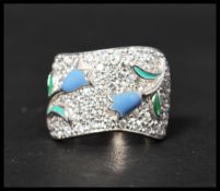 A hallmarked 925 silver band ring having applied enamel flowers set amongst pave set CZ.