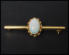 A hallmarked 9ct gold and opal brooch pin set with a single opal cabochon in a twist setting