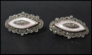 A vintage pair of 925 silver large clip-on earrings decorated with marcasite and mother of pearl.