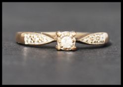 A hallmarked 9ct gold ad diamond ring set with a central round cut diamond with diamond set