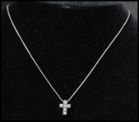 A hallmarked 18ct white gold and diamond pendant necklace strung with a white gold crucifix set with
