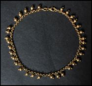 A hallmarked 9ct gold ankle bracelet having ball finials and lobster claw clasp. Hallmarked