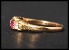 An antique 18ct gold 5 stone ring set with diamond rubies and other white stones. The ring having