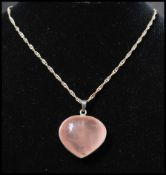 A 925 silver pendant necklace strung with a large rose quartz heart pendant on a twist link chain