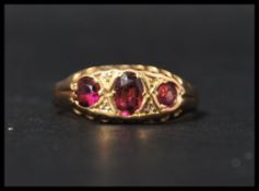 A hallmarked 18ct gold and three stone ring having oval cut amethyst in a gypsy setting.