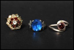 Three silver dress rings, two marked silver. Sizes - red stone P, Cluster N, Blue marcasite N.5.