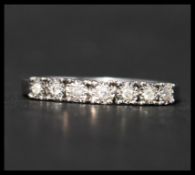 A hallmarked 9ct white gold and diamond half eternity ring. The ring having 7 illusion set diamonds.