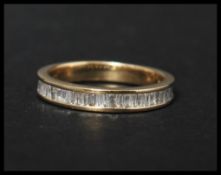 A hallmarked 9ct gold and diamond half eternity ring set with baguette cut diamonds. Diamonds approx