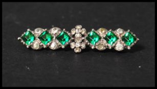 An early 20th century white metal brooch set with green and white paste stones having a C Clasp.