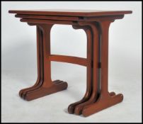 A 1970's / 20th century G-Plan teak wood nest of three inter-sliding occasional tables, raised on