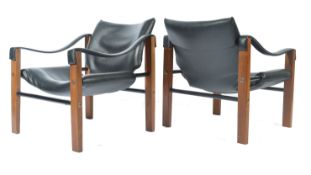 A pair of mid 20th Century Maurice Burke Arkana safari chairs / arm,chairs. Each with faux black