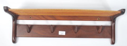 A vintage mid 20th century retro teak wood coat rack of angular  form having a railed rack above