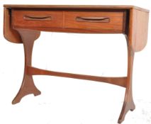 A 1970's retro G-Plan teak wood drop side writing table being raised on splayed legs with
