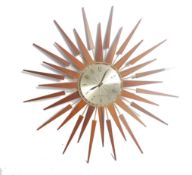 A vintage mid century teak wood sunburst wall clock by Seth Thomas. The teak rays with gilded