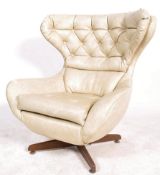 A good 1960's believed Greaves & Thomas  retro  batwing swivel armchair being raised on a teak