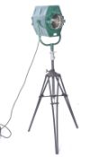 A mid century vintage film - theatre spot light being raised on a large vintage Photax tripod